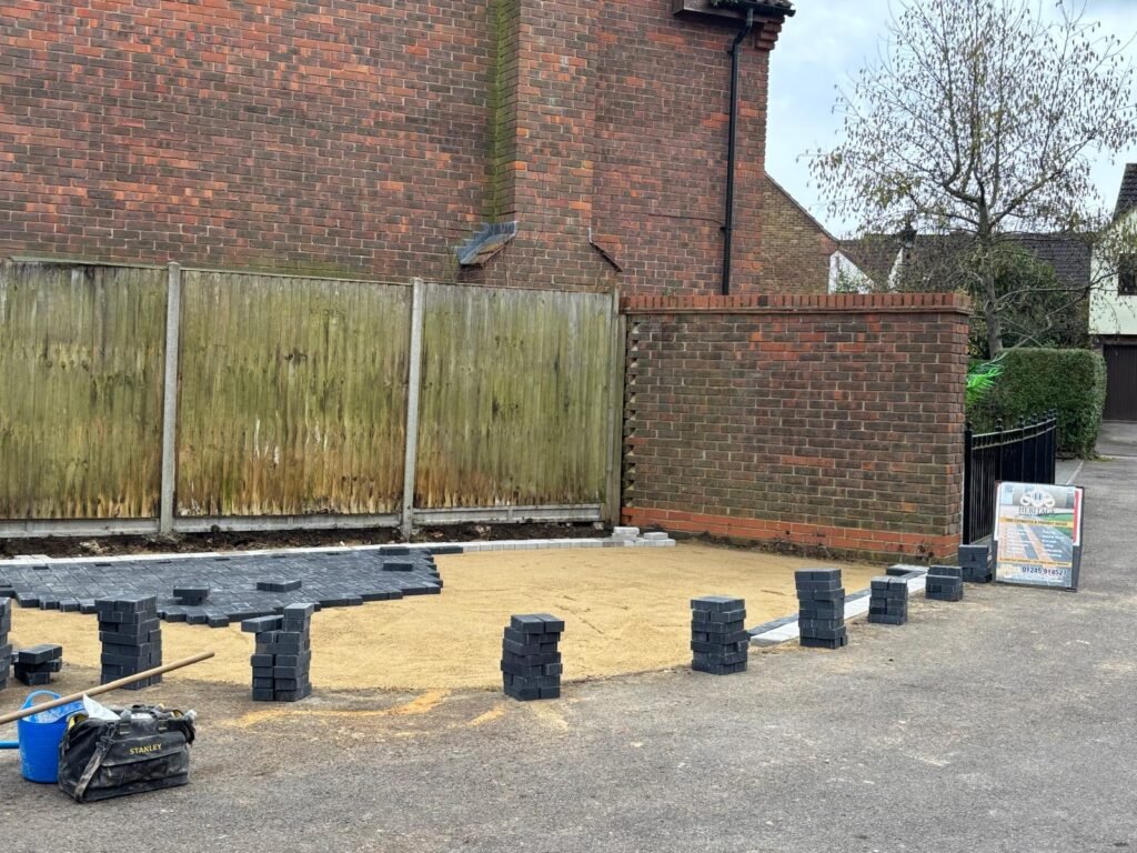 Base layer and edging stones laid out for driveway installation – groundwork in Essex