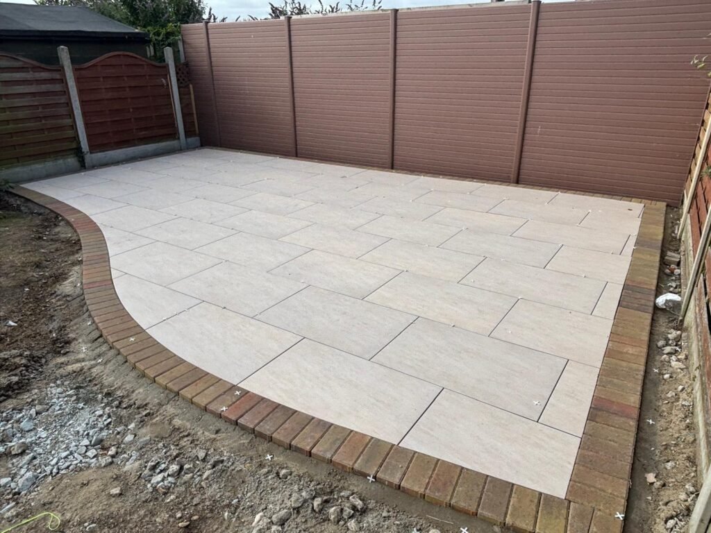 Porcelain patio paving with curved edging – modern garden renovation in Essex