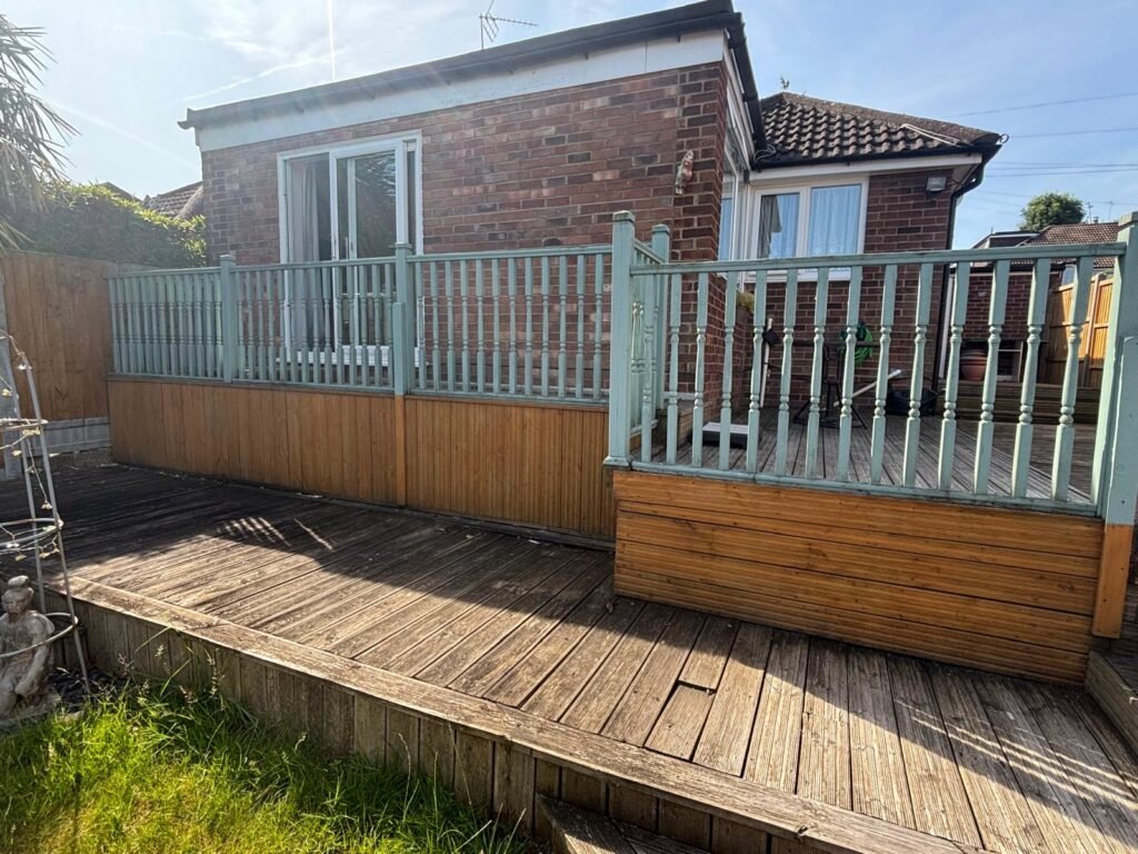 Old timber decking with painted balustrade prior to garden renovation