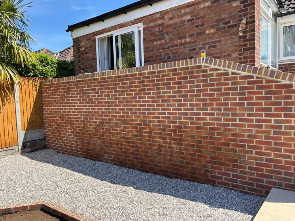 Decorative red brick garden wall installation with gravel surfacing – Essex landscaping project