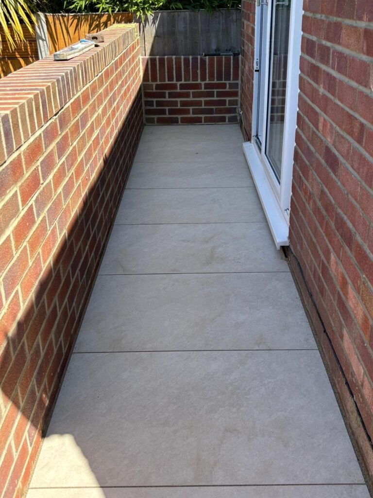 Modern patio paving with large porcelain slabs beside house – Essex garden hardscaping